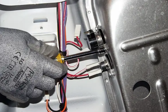 PHOTO: Remove the high-limit thermostat mounting screws.