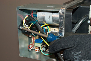 Remove the mounting screw from the fan capacitor.