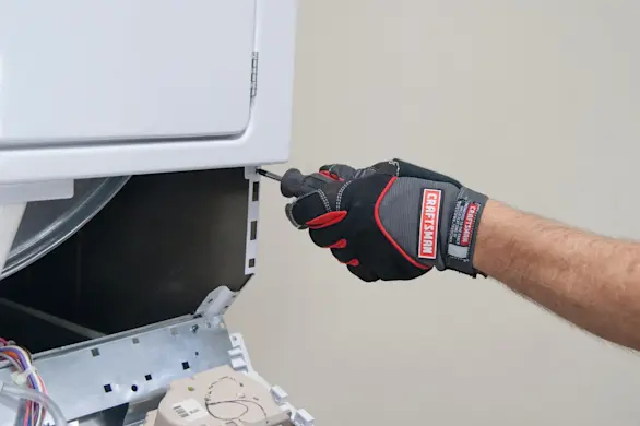 PHOTO: Remove the bottom screws from the dryer front panel.