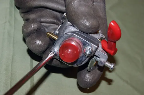 PHOTO: Remove the screws from the carburetor top cover.
