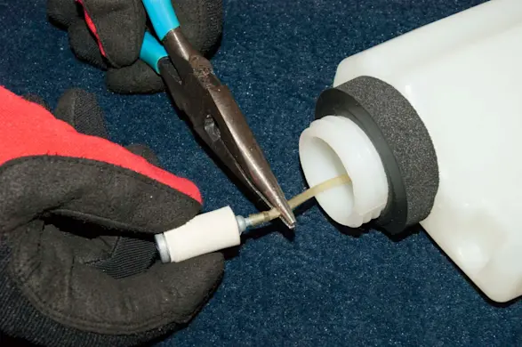 PHOTO: Pull the fuel filter out of the mouth of the tank.