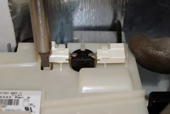 PHOTO: Release the locking tabs on the thermal fuse.