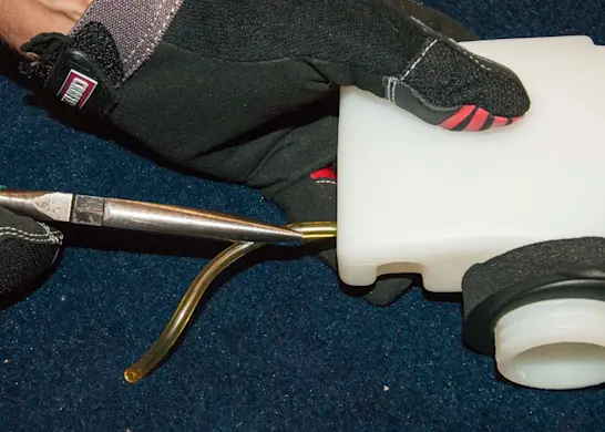 PHOTO: Tug the fuel line to position the grommet.