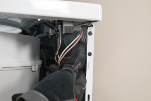 PHOTO: Remove the screw from under the right front corner of the top panel.