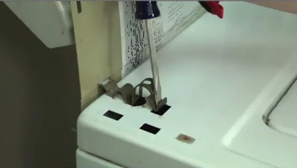 PHOTO: Release the clips that hold the cabinet to the back panel.