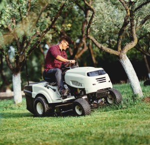 Image of lawn tractor or riding mower driving up a hill