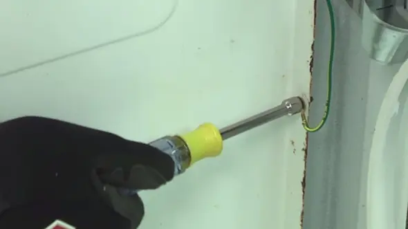PHOTO: Connect the green ground wire to the cabinet.