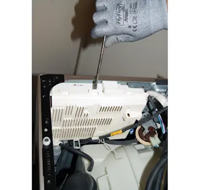 PHOTO: Remove the front cover of the machine control board housing.