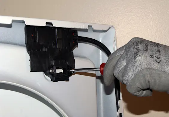 PHOTO: Remove the lid switch/lock assembly mounting screws.