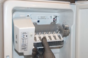 PHOTO: Lower and flip the ice maker to access its wiring harness.
