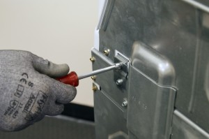 PHOTO: Remove the top screws from the hinges.