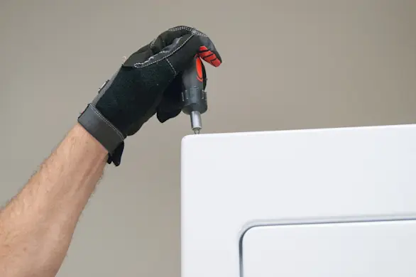 PHOTO: Remove the top screws from the dryer front panel.