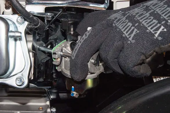 PHOTO: Slide the new carburetor onto the mounting studs.