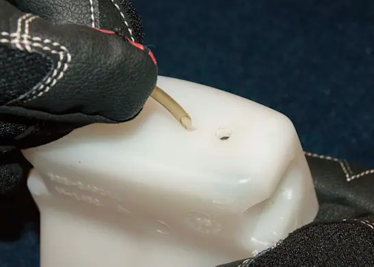 PHOTO: Push the angled end of the fuel line through the mounting hole.
