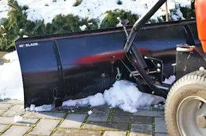 Image of lawn tractor clearing snow with a snow blade