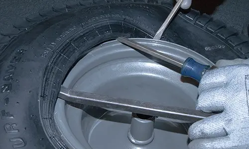 PHOTO: Break the tire bead and pry the tire off the rim.