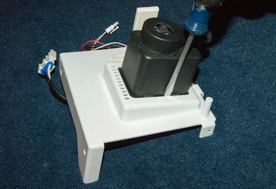 PHOTO: Pry the recirculation pump out of the bracket.