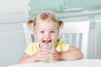 Smiling girl drinking glass of water