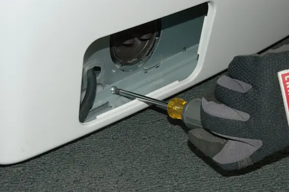 PHOTO: Remove the mounting screw from the bottom of the front panel.