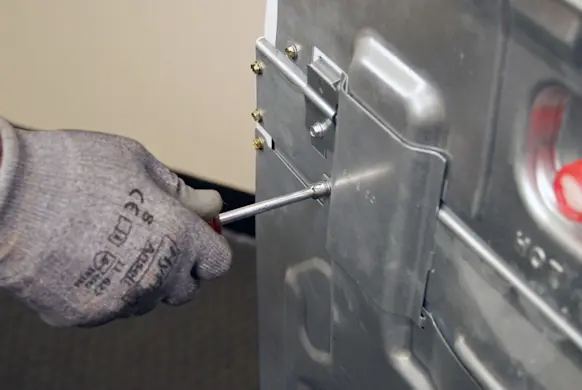 PHOTO: Remove the screw from the wire cover.