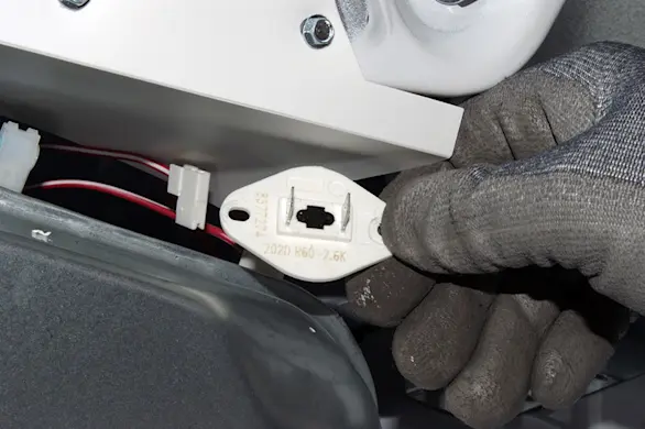PHOTO: Remove the thermistor from the blower housing.