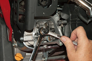 Loosen the jam nut while holding the fulcrum stationary.