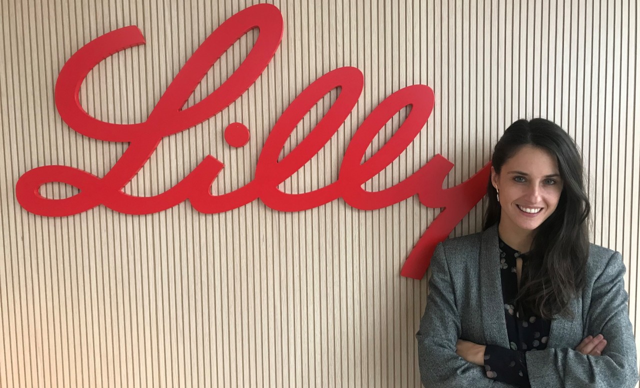 Mujer delante de un logotipo de Lilly
