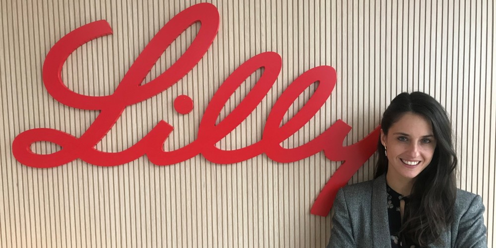 Mujer delante de un logotipo de Lilly
