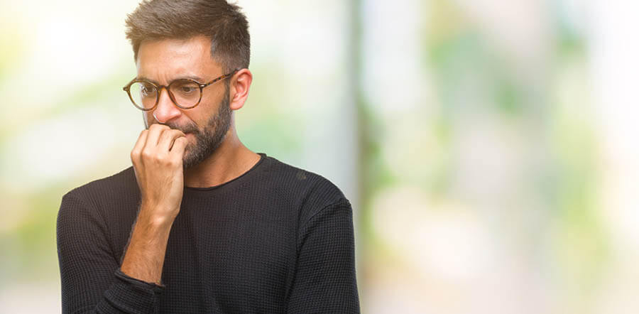 Un hombre mordiendo las uñas con cara de preocupación