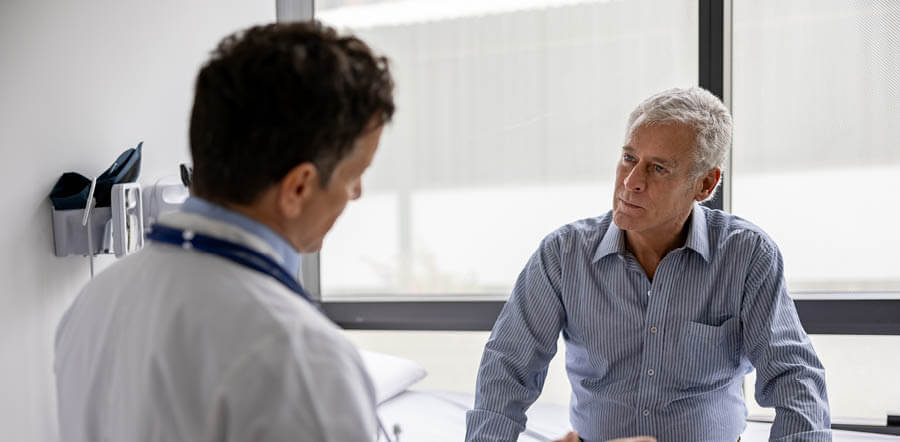 hombre de mediana edad reuniéndose con su médico