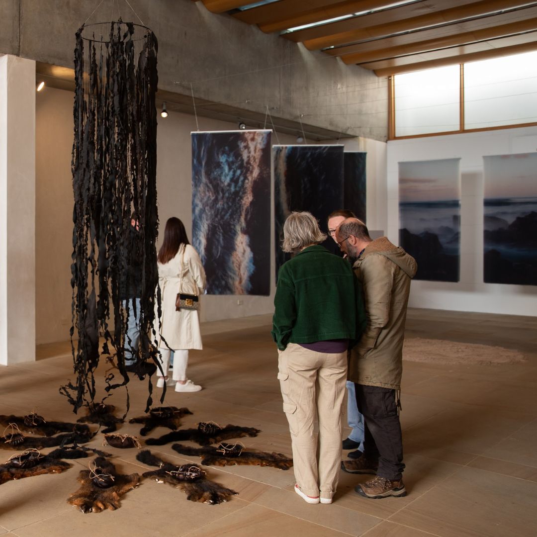 a kelp chandelier is suspended from the ceiling, around the base - fanned out - are possum skins topped with kelp water carriers