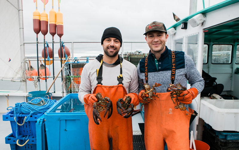 A photo of Jim & Sabin of Cousins Maine Lobster holding lobsters