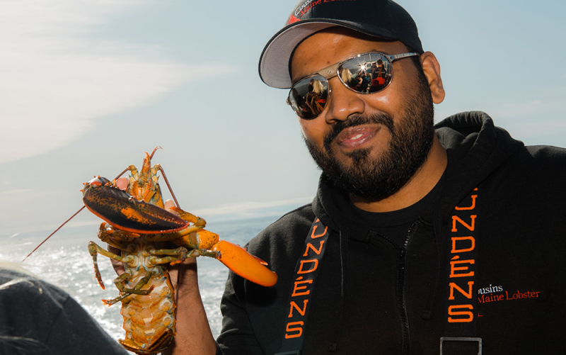 A photo of our NYC & CT franchisee holding a lobster while out fishing in Maine.