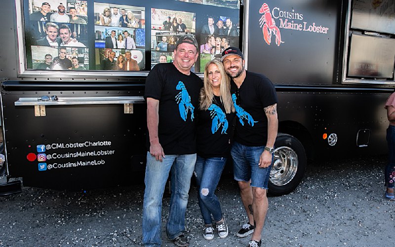 A photo of our Charlotte owners in front of their food truck with Cousin Sabin.