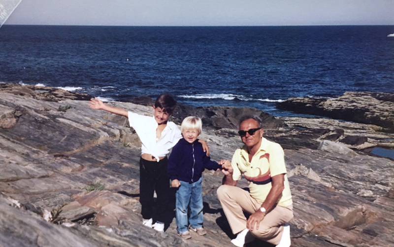 A photo of Cousins Maine Lobster founders, Jim and Sabin, as young kids with their grandad, on the rocky Maine coast.