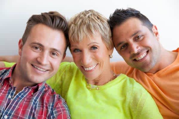 A closeup photo of Cousins Jim & Sabin with their heads leaning against Barbara Corcoran.