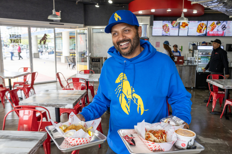 Raj Mohan gleams as he carries two trays of food inside the Pier 41 Cousins Maine Lobster Restaurant!