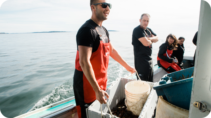 An image of Cousin Jim on board a lobster boat, moving a crate of lobsters.