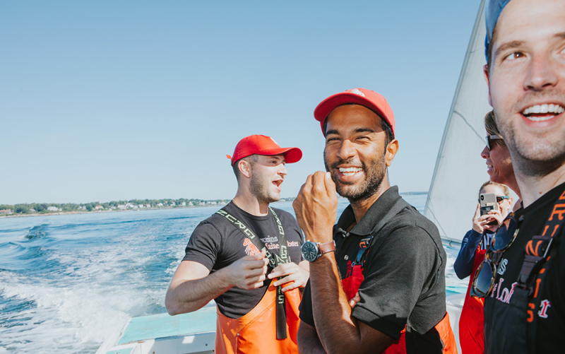 A photo of our Orange County owner smiling aboard a lobster boat with other CML family members nearby.