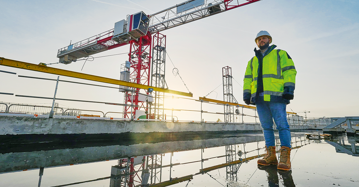 A construction worker stands idle on a jobsite