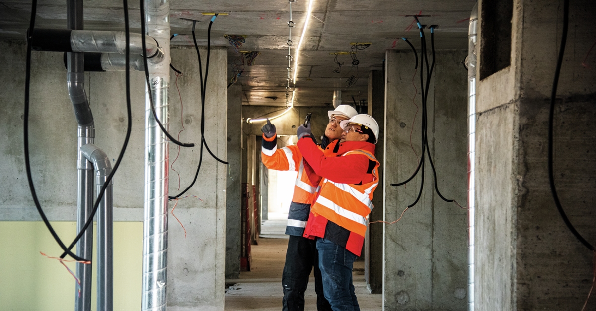 Two construction workers inspect a jobsite using Fieldwire's construction management app