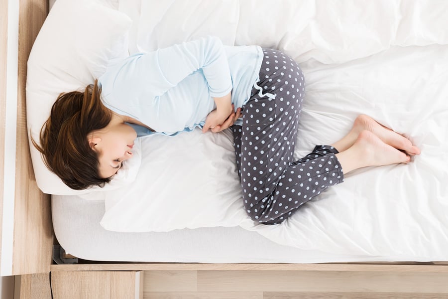 Frau hat Schmerzen durch Menstruationskrämpfe