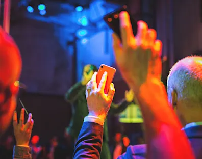 manos extendidas que graban un evento con el móvil