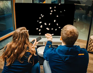 amigos viendo la tele mientras comen palomitas