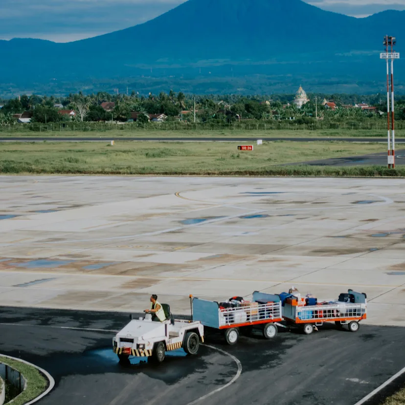 Hombre conduciendo un carro de aeropuerto Hombre conduciendo un carro de aeropuerto