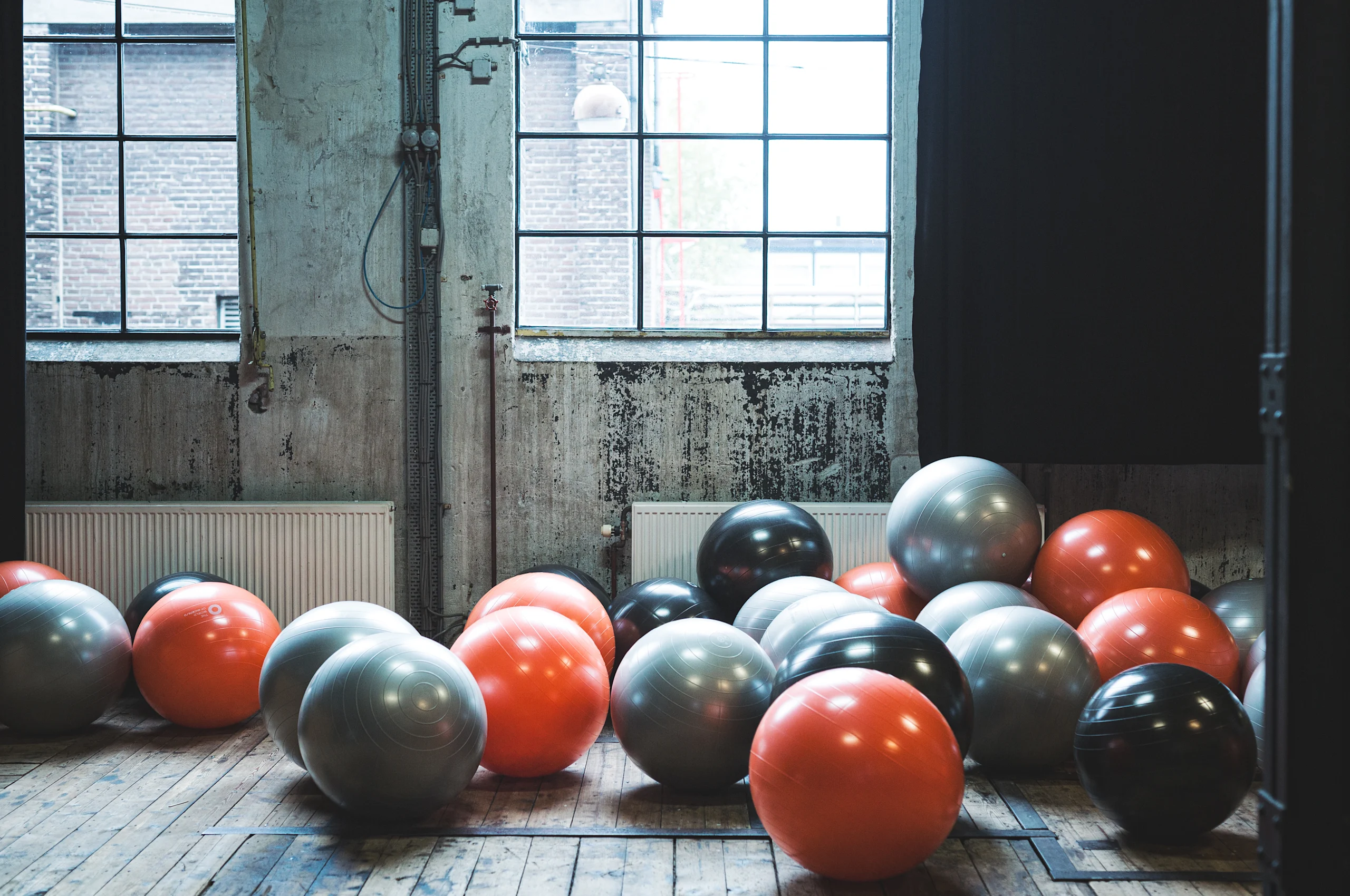 Pelotas de gimnasio en una sala con ventana de fondo