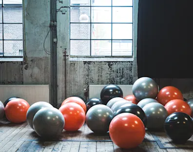 Pelotas de gimnasio en una sala con ventana de fondo