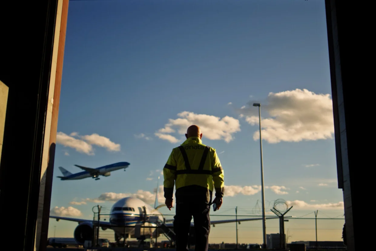Operario en aeropuerto gestionando envíos con solución cloud de automatización logística en Schiphol