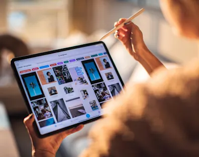 Persona sostiene un ipad que muestra fotografías de distintos tamaños.