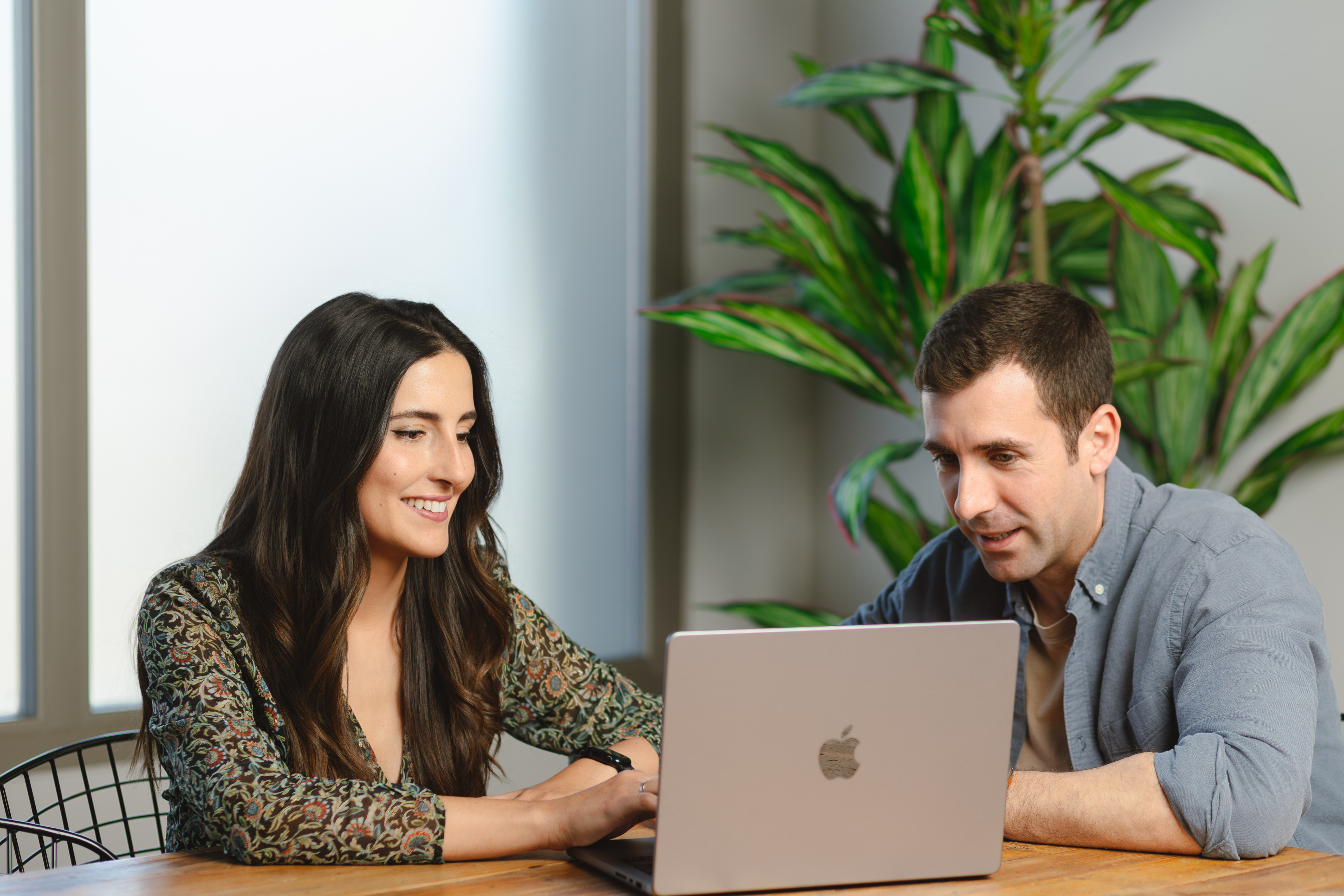 Dos personas hablan mientras miran un ordenador.